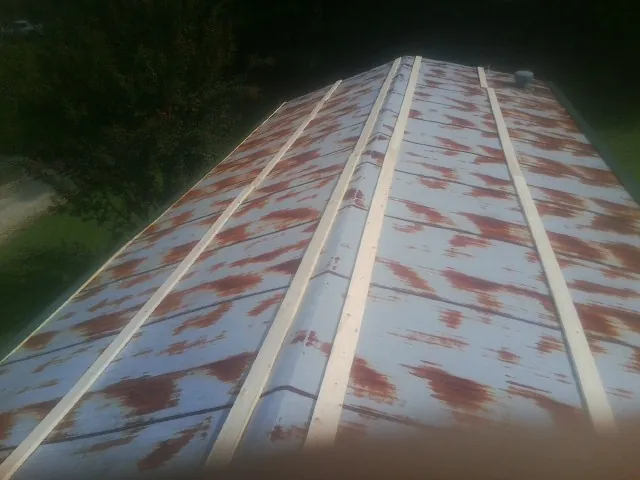 Rusted metal roof panels with new wood purlins before replacement — Storm Damage Roof Repair in Magazine by Roofing Brothers