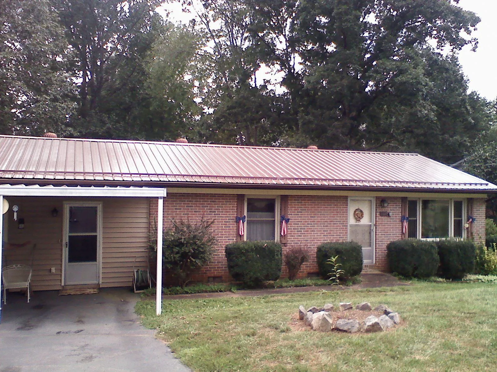 Bronze metal roof and carport on a brick ranch home — Roof Repair work by our crew in Magazine